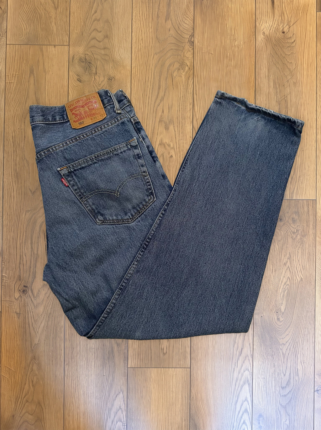 Vintage Levi's 550 jeans in distressed mid wash — folded