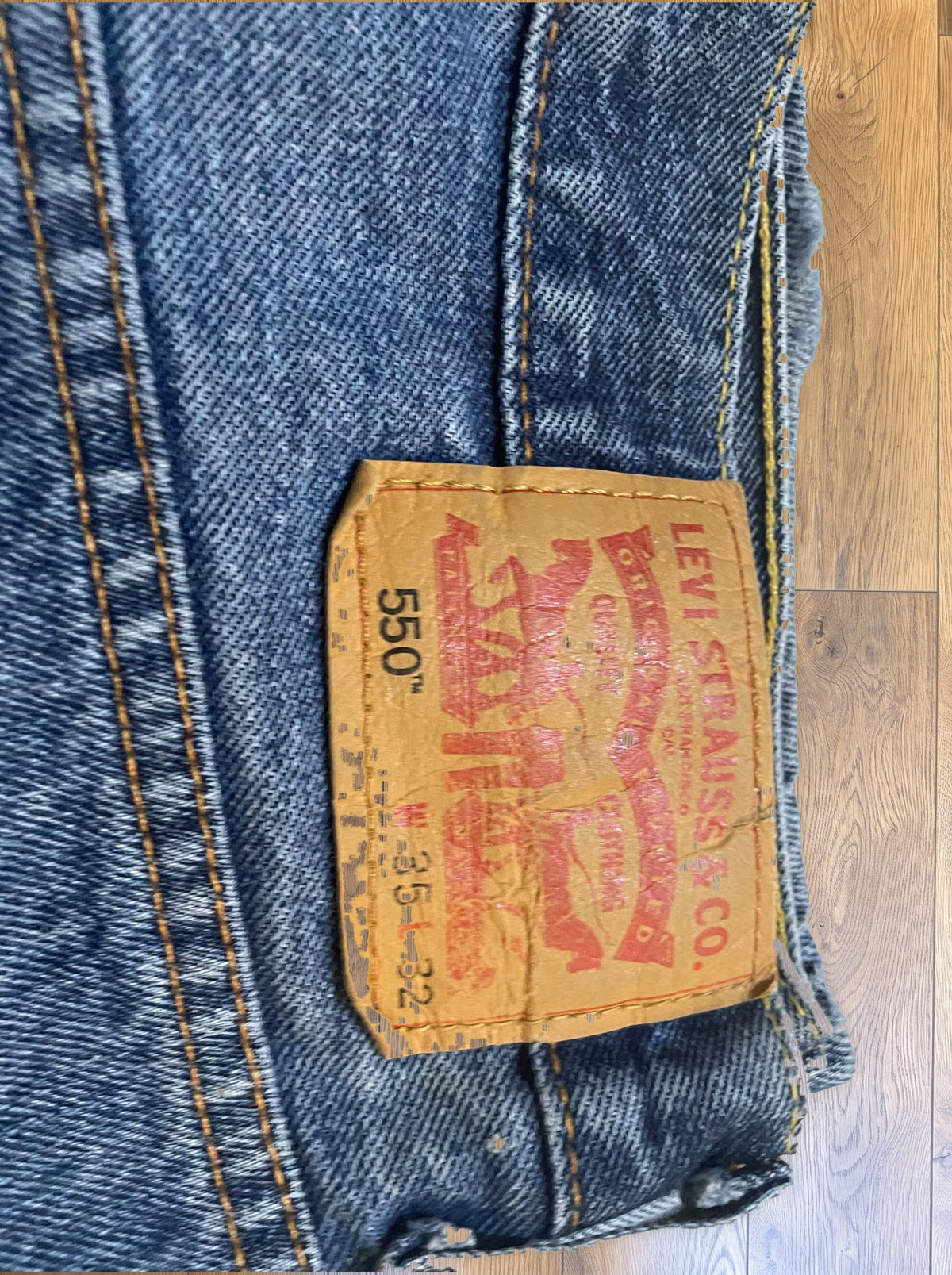 Vintage Levi's 550 jeans in distressed mid wash — detail